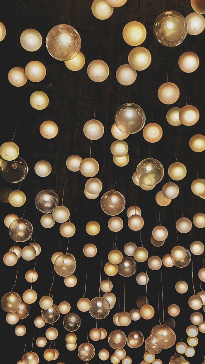 Mesmerizing display of illuminated hanging bulbs against a dark background, showcasing modern lighting design.